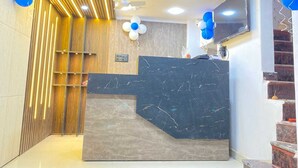A reception area with a marble counter, wooden paneling, and blue balloons. - Hotel ornate  (Chandauli)
