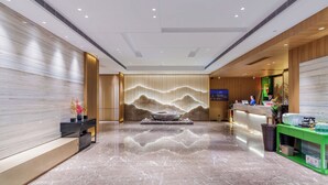 A modern hotel lobby with a reception desk, a decorative wall, and a marble floor. - LIZ International Hotel Guangzhou Olympic Sports Center International Financial City Branch - Free Shuttle Bus to Canton Fair Complex During Canton Fair Period (Guangzhou)