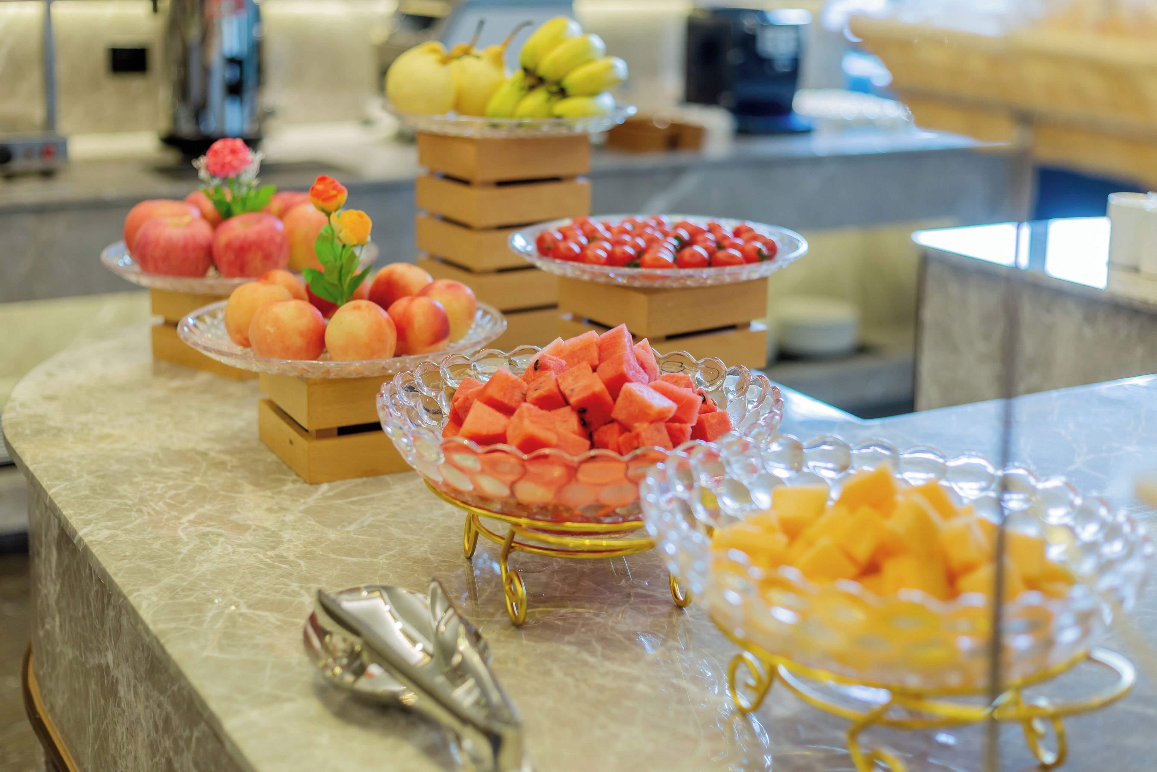 Un buffet proposant une variété de fruits, avec une machine à café en arrière-plan.