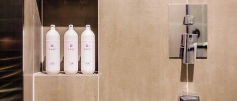 A bathroom with three white bottles labeled 'LIZETEL' and a modern shower with a control panel.