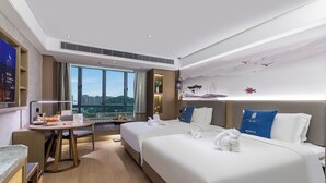 A hotel room with two beds, a desk, a view of the city, and a mural on the wall. - LIZ International Hotel Guangzhou Olympic Sports Center International Financial City Branch - Free Shuttle Bus to Canton Fair Complex During Canton Fair Period (Guangzhou)