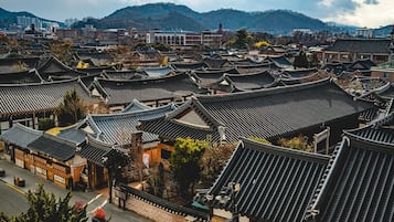 A traditional Korean village with multiple buildings featuring curved, tiled roofs.