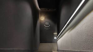 Eine moderne Treppe führt zu einem privaten Wellnessbereich, mit einem Schild, das den Standort anzeigt.