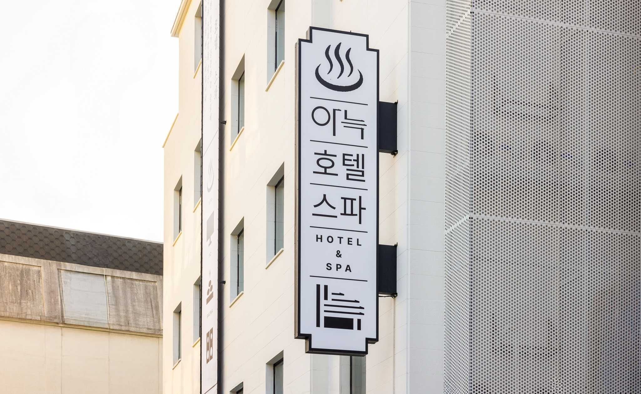 A hotel and spa sign with Korean characters and symbols indicating a hot spring facility.