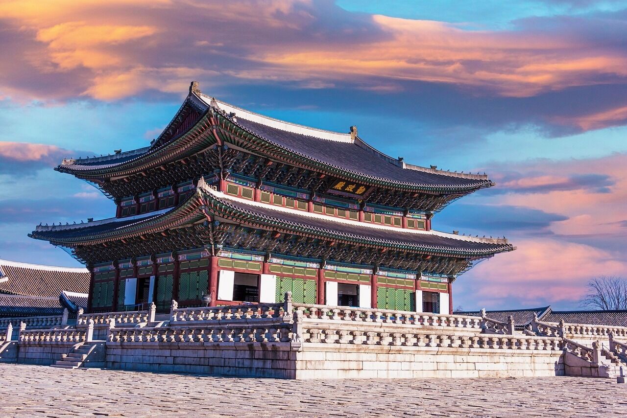 A traditional Korean palace with a multi-tiered roof and ornate decorations.