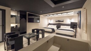 Ein modernes Hotelzimmer mit einem großen Bett, einem Schreibtisch und einer Sitzecke.