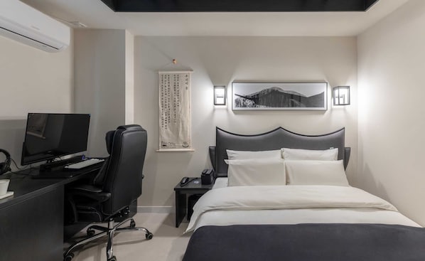 A hotel room with a bed, a desk with a computer, a chair, a nightstand, and a wall-mounted picture. - Anook Hotel and Spa Seoul Jongno Anguk 1st (Seoul)