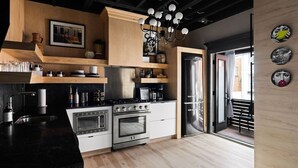 A modern kitchen with a central island, built-in appliances, and wooden accents. - 258 38th St. - Brownstone (Pittsburgh)