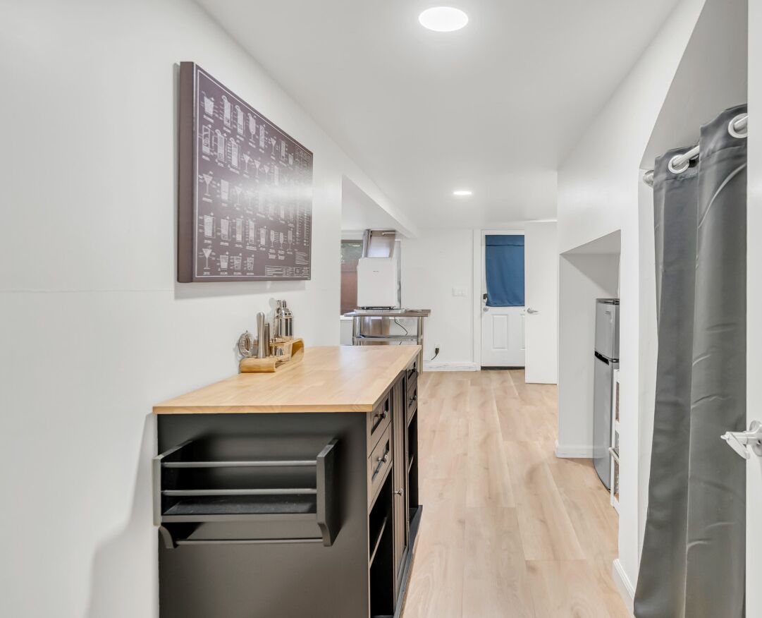 Cocina moderna con encimera de madera, electrodomésticos integrados y vistas al comedor.