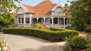 A two-story house with a red-tiled roof, white exterior, and a covered porch. - Anglesea House Inn (Blenheim)