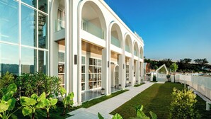 A modern building with large glass windows and white arches. - Masuland (Shantou)