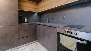 Une cuisine moderne équipée d’un four encastré, d’un évier et d’une machine à café.