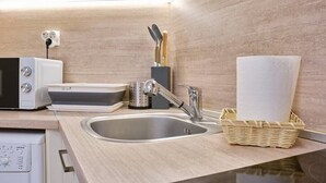 A kitchen with a sink, microwave, toaster, and a basket of paper towels. - Cozy 1-bed Apartment 2 (Plovdiv)