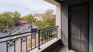 A balcony with a view of a busy street and a building in the background. - Cozy 1-bed Apartment (Plovdiv)