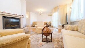 A living room with a fireplace, a globe, and a television.
