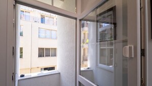 A narrow corridor with a glass door leading to a balcony.