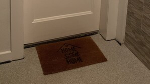 A white door with a keyhole and a doormat with "HOME Sweet HOME" text. - Accogliente appartamento (Wuppertal)