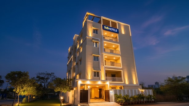 A multi-story hotel with a 'tabHOTELS' sign, featuring balconies, a gated entrance, and a well-lit facade. - Fabhotel Rk Suites (Hyderabad)