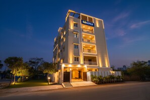 A multi-story hotel with a 'tabHOTELS' sign, featuring balconies, a gated entrance, and a well-lit facade. - Fabhotel Rk Suites (Hyderabad)