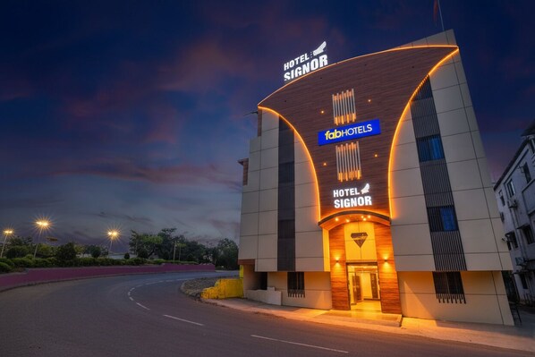 A modern hotel with a curved facade, a prominent sign for 'Hotel Signor', and the 'fabHotels' logo. - Fabhotel Prime Signor - Airport (Indore)