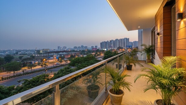A balcony with a view of a cityscape, including high-rise buildings and a highway. - Fabhotel Ar Suites (Gurugram)