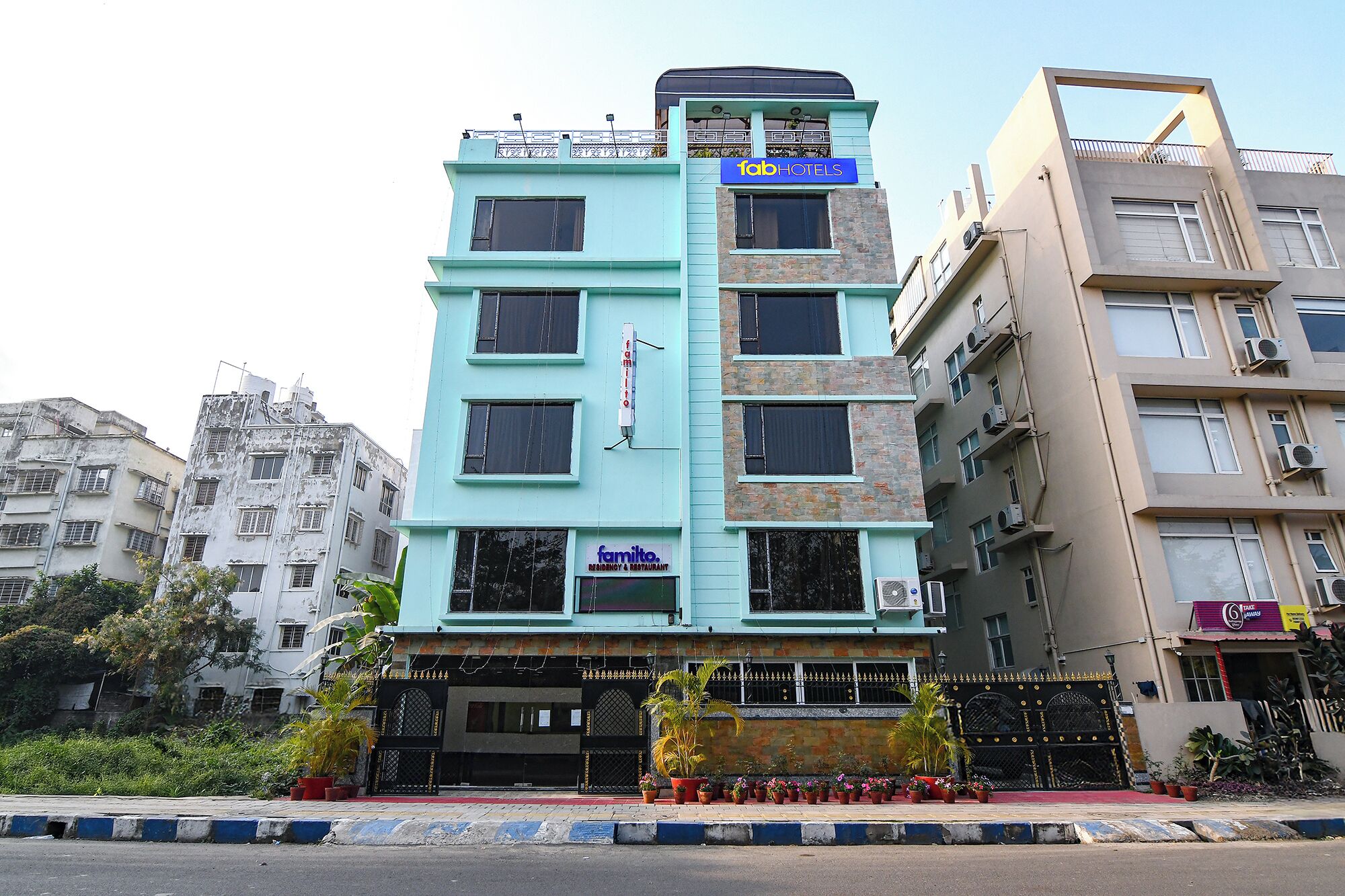 Um edifício de vários andares com uma placa chamativa 'fab hotels'.