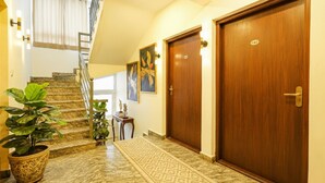 Ein Hotelkorridor mit Treppe, Holztüren und einem gemusterten Teppich.