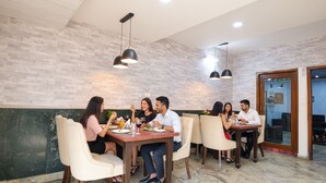 Un restaurante con un interior moderno, que presenta una pared de ladrillo, iluminación colgante y suelos de mármol.