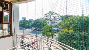 Un balcón con vistas a un paisaje urbano, que incluye edificios y árboles.