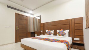 Ein Schlafzimmer mit einem hölzernen Bettgestell, einem großen Spiegel und einem Nachttisch mit Schublade.