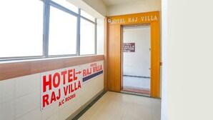 A corridor with signs indicating the Hotel Raj Villa and its A/C rooms. - Fabhotel Raj Villa (Gandhinagar)