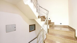 A staircase with metal railings and beige steps. - Fabhotel Just Inn (New Delhi)