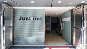 A hotel entrance with a tiled wall displaying "Just inn" and a visible interior with a piano. - Fabhotel Just Inn (New Delhi)