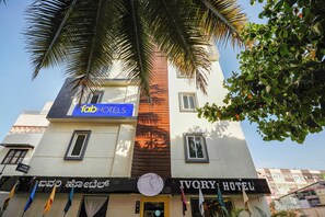 Un hôtel avec une enseigne indiquant « Tab Hotels » et une autre indiquant « Ivory Hotel ».