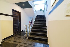 A staircase with a handrail, a door, and a window at the top.