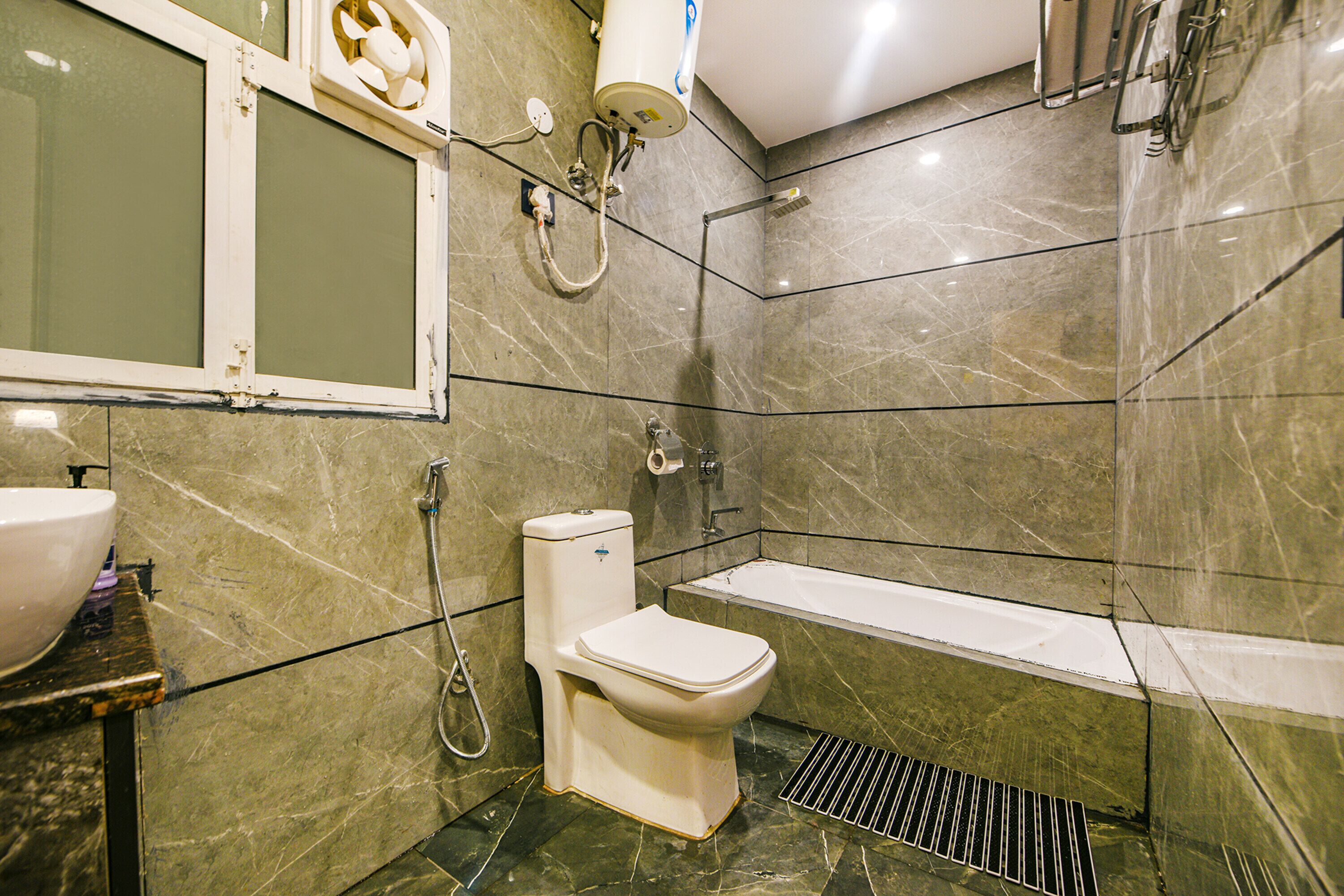 A bathroom with a toilet, sink, and bathtub.