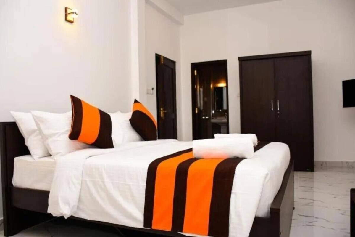 A hotel room with a bed, a wardrobe, and a television.