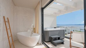 Une salle de bain moderne avec une baignoire sur pieds, une échelle en bois et un sauna.