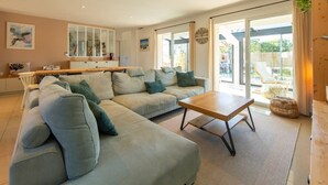 A modern living room with a sectional sofa, a wooden coffee table, and large sliding glass doors leading to a balcony.