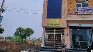 A building with a sign indicating AC rooms available. - Shree Krishna Valley (Vrindavan)