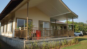 A two-story house with a covered porch and a garage. - Mango Shack Villa (Trimbak)