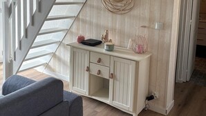 A staircase leading to a second floor, a white console table with drawers, and a wall-mounted mirror.