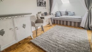 Ein Schlafzimmer mit einem Bett, einem Schreibtisch, einem Stuhl, einem Teppich und einem Bild an der Wand.