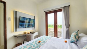 A hotel room with a bed, a desk, a TV, and a view of the outdoors.