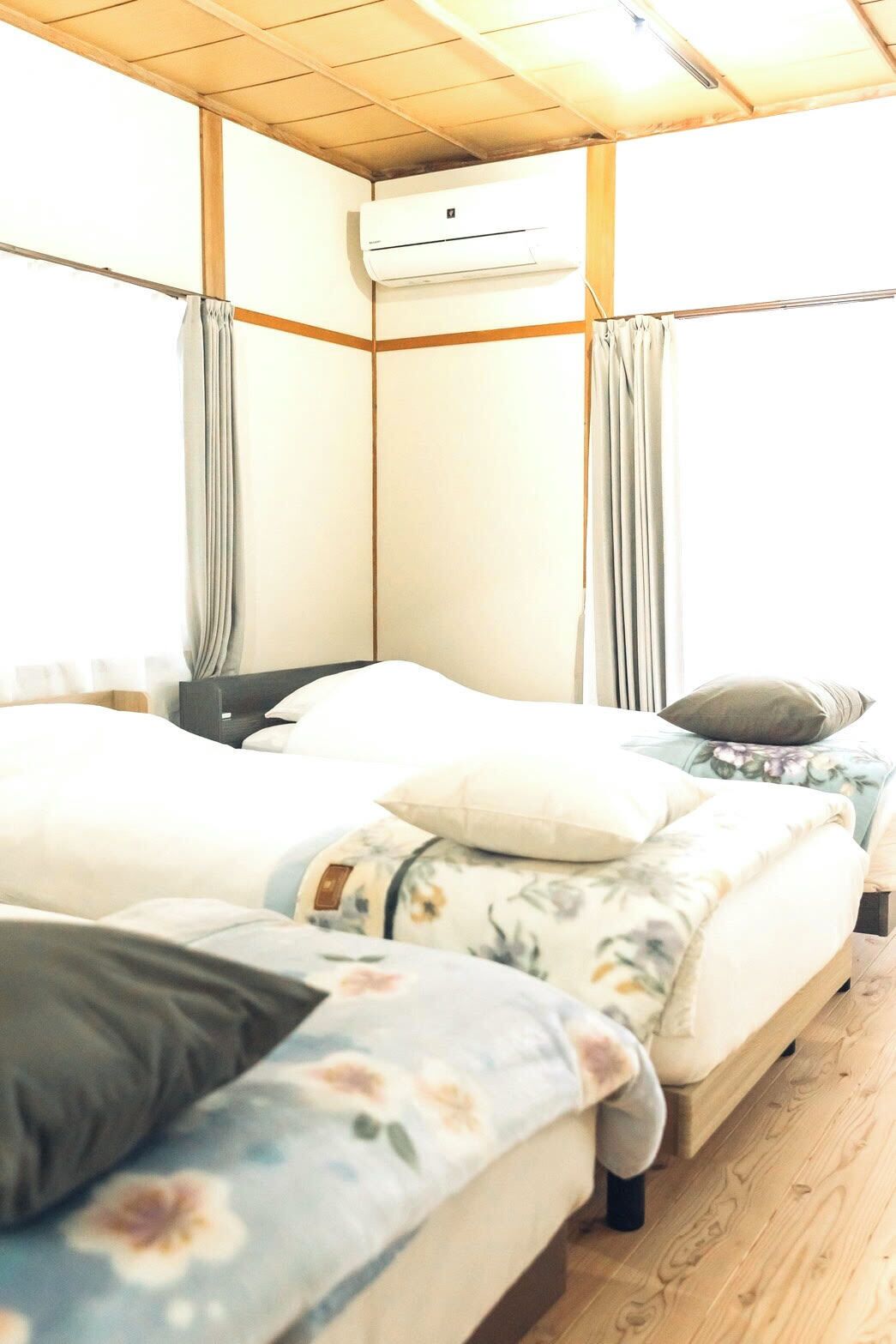 Una habitación con cama, mesita de noche y aire acondicionado.