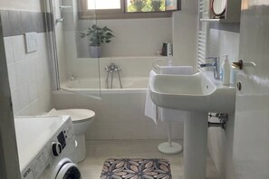 Een haardroger, een bidet, handdoeken, toiletpapier