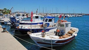 A marina with several boats docked, featuring a variety of sizes and designs.