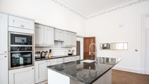 A modern kitchen with white cabinetry, a granite countertop, and stainless steel appliances. - The Montague (Durham)