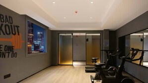 A gym with exercise bikes, a cityscape view, and motivational wall art. - Mcsrh Hotel-Changsha Shaoshanbeilu (Changsha)