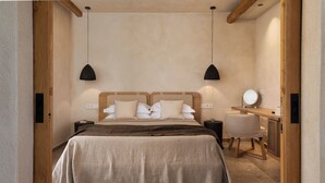 A bedroom with a large bed, two bedside tables, a desk, and a chair.